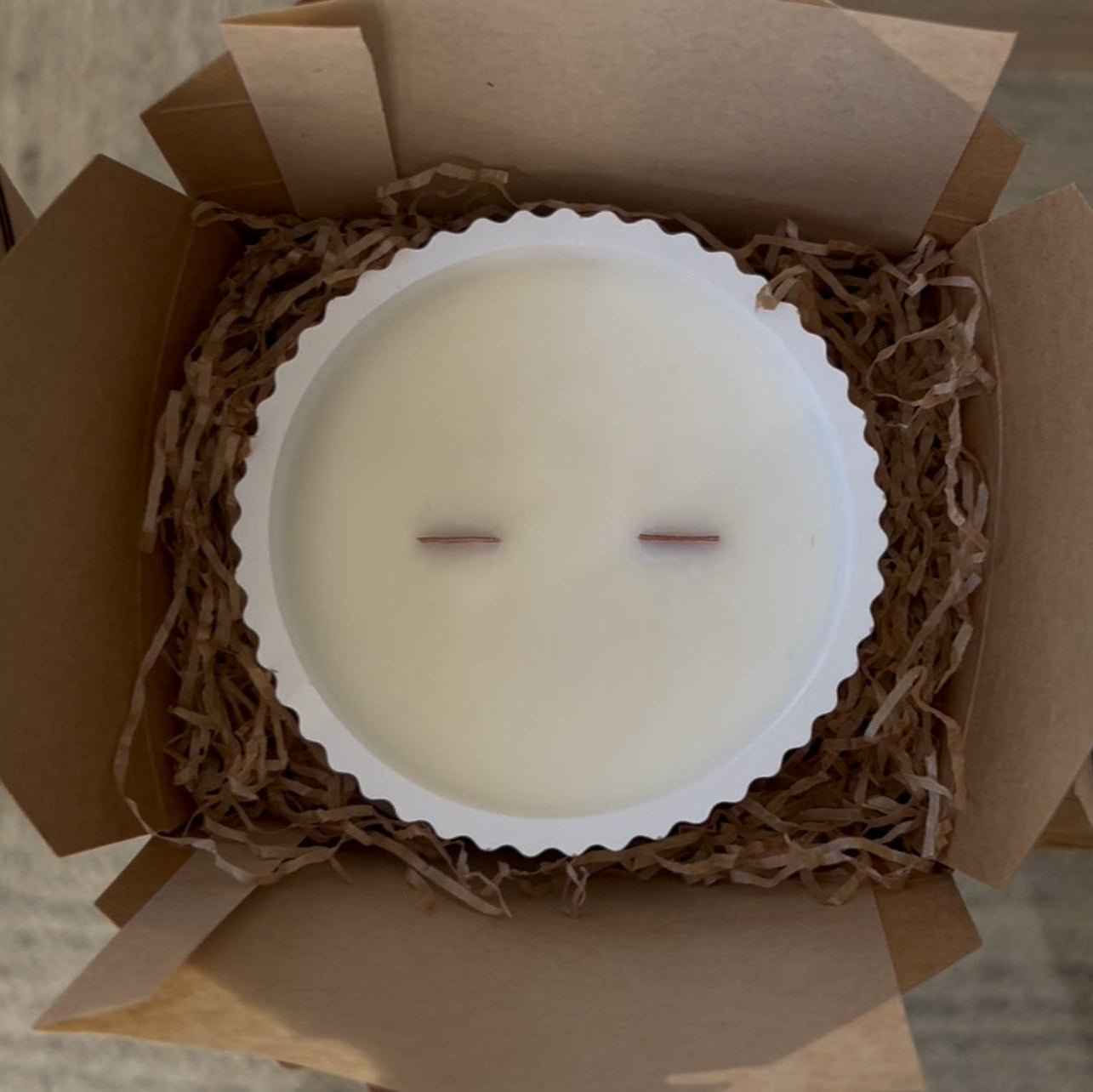 Vela aromática de soja presentada como regalo artesanal en packaging sostenible