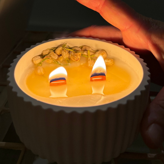 vela soja encendida de jazmín cera derretida y llama cálida decorada con flores y con pabilo de madera
