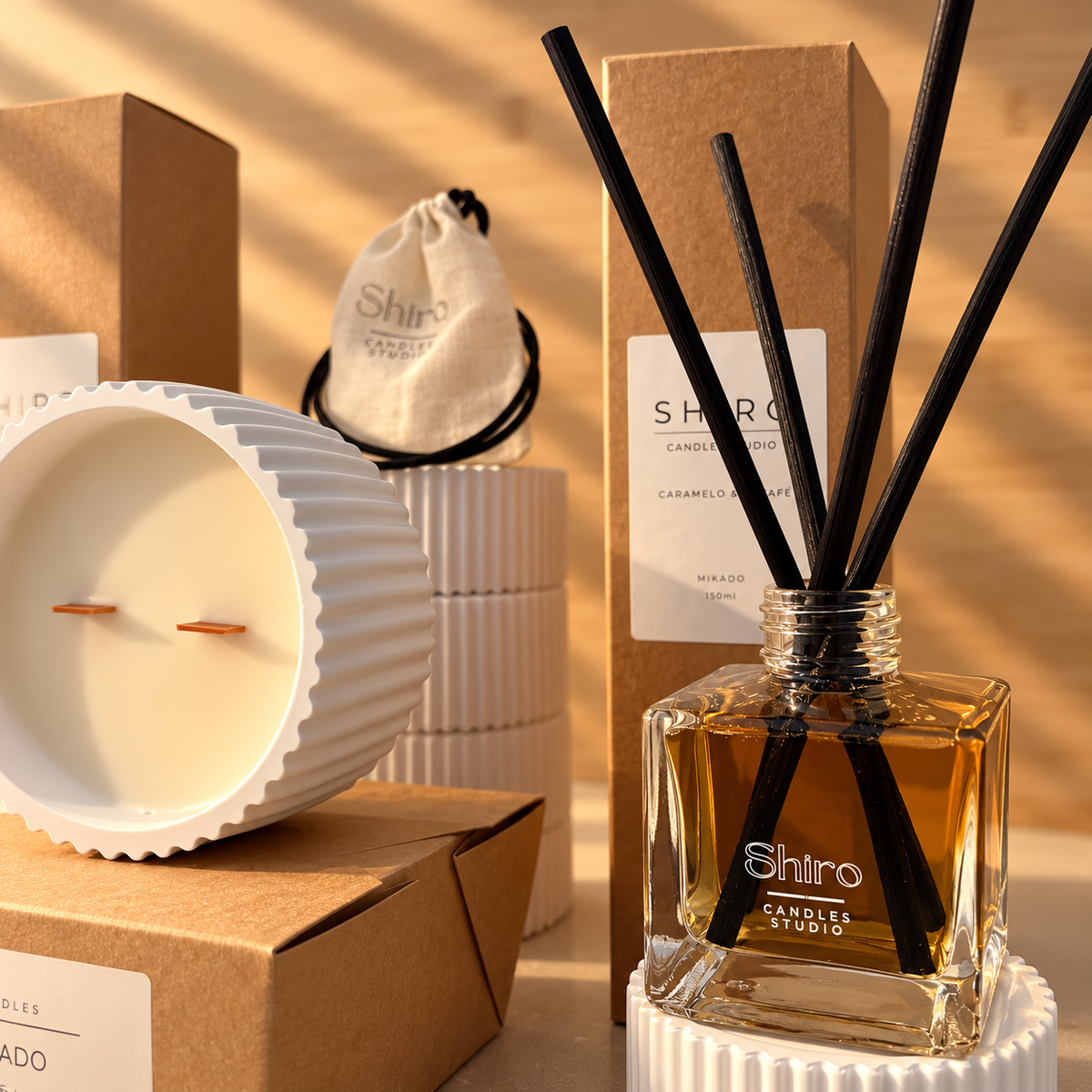 Mikado Caramelo & Café de Shiro Candles Studio con varillas negras, presentado junto a la vela aromática del pack Aroma Total para perfumar el hogar.