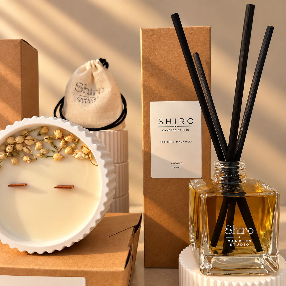 Mikado aromático Jazmín & Magnolia de Shiro Candles Studio con varillas negras, presentado junto a la vela del pack Aroma Total para perfumar el hogar.