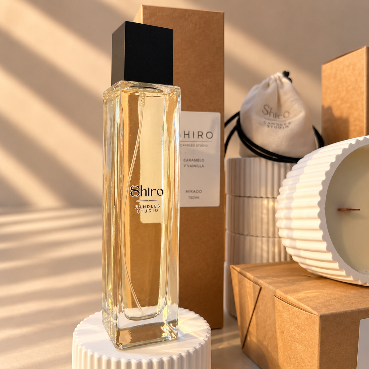 Perfume de hogar Caramelo & Vainilla de Shiro Candles Studio en frasco de cristal de 100 ml, presentado junto a la vela aromática y el packaging del pack Aroma Total.