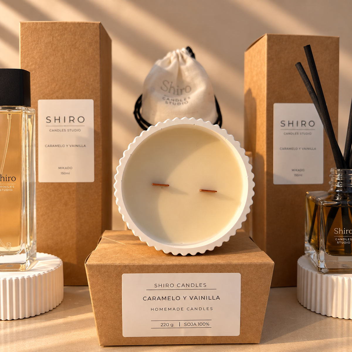 Vela aromática de soja Caramelo & Vainilla de Shiro Candles Studio, con doble mecha de madera y cuenco blanco artesanal, presentada junto al mikado y perfume de hogar del pack Aroma Total.