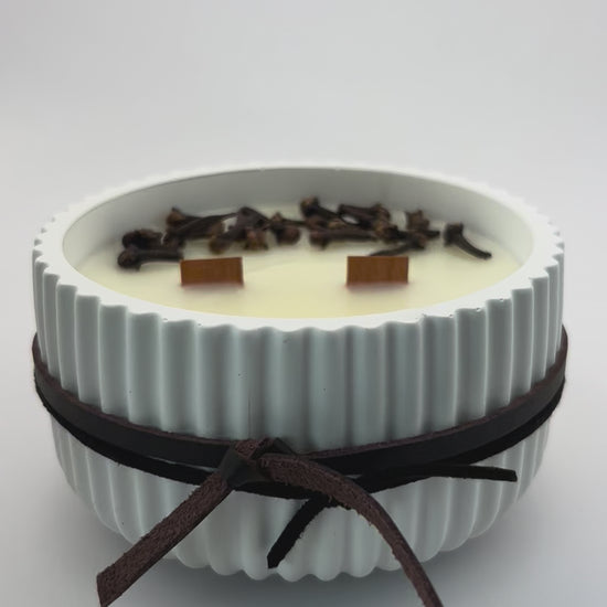 “Vela aromática artesanal de cera de soja con doble mecha de madera en escritorio de trabajo con ordenador portátil, decoración elegante ideal regalo masculino.