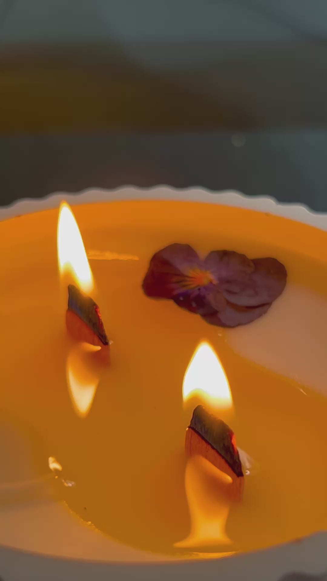Vídeo de vela aromática de violeta y vainilla blanca con doble mecha de madera encendida, elaborada artesanalmente con cera de soja natural.