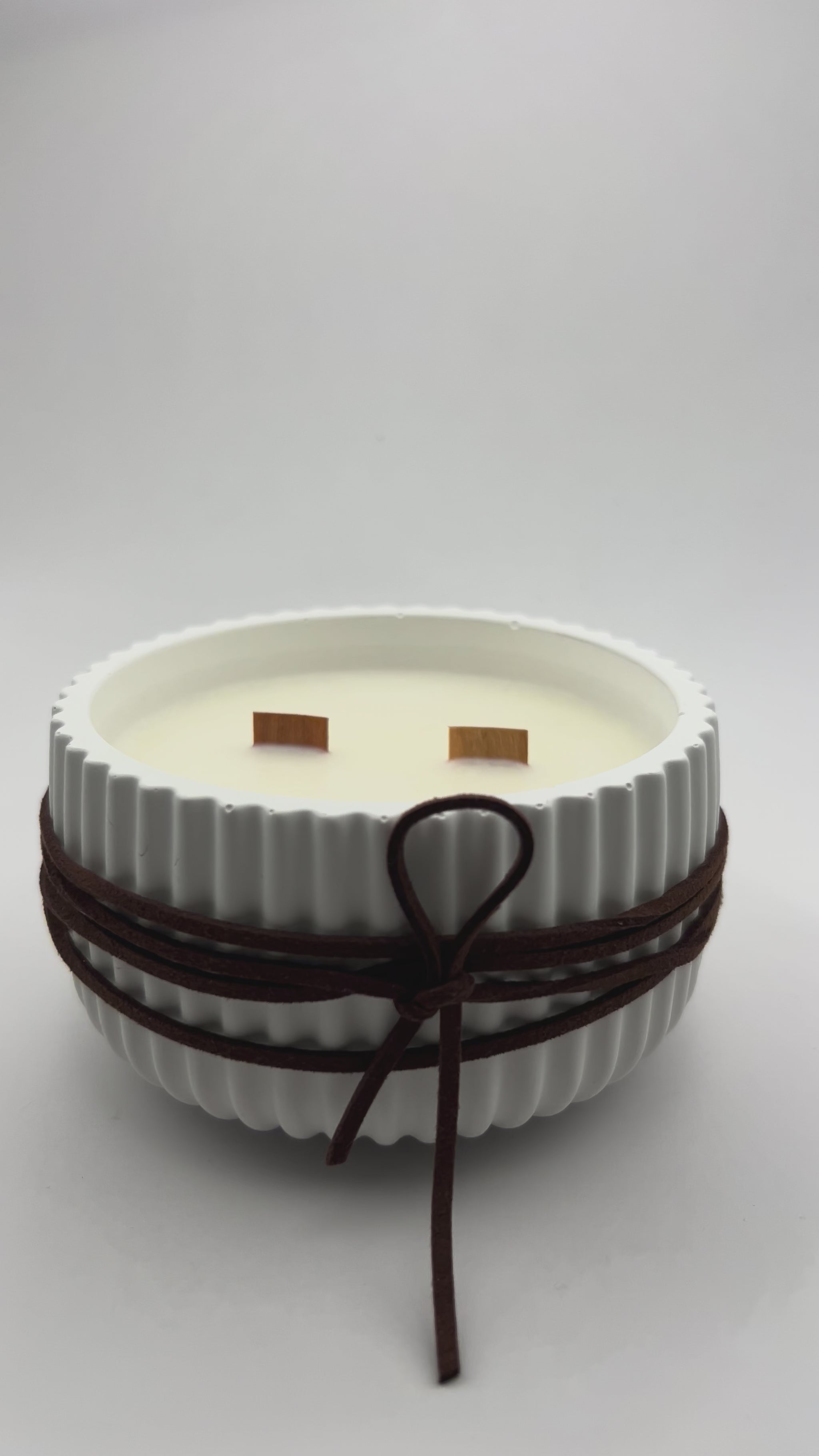 video de vela de cera de soja aromática de tobacco y roble decorada con cinta símil ante con doble mecha de madera.