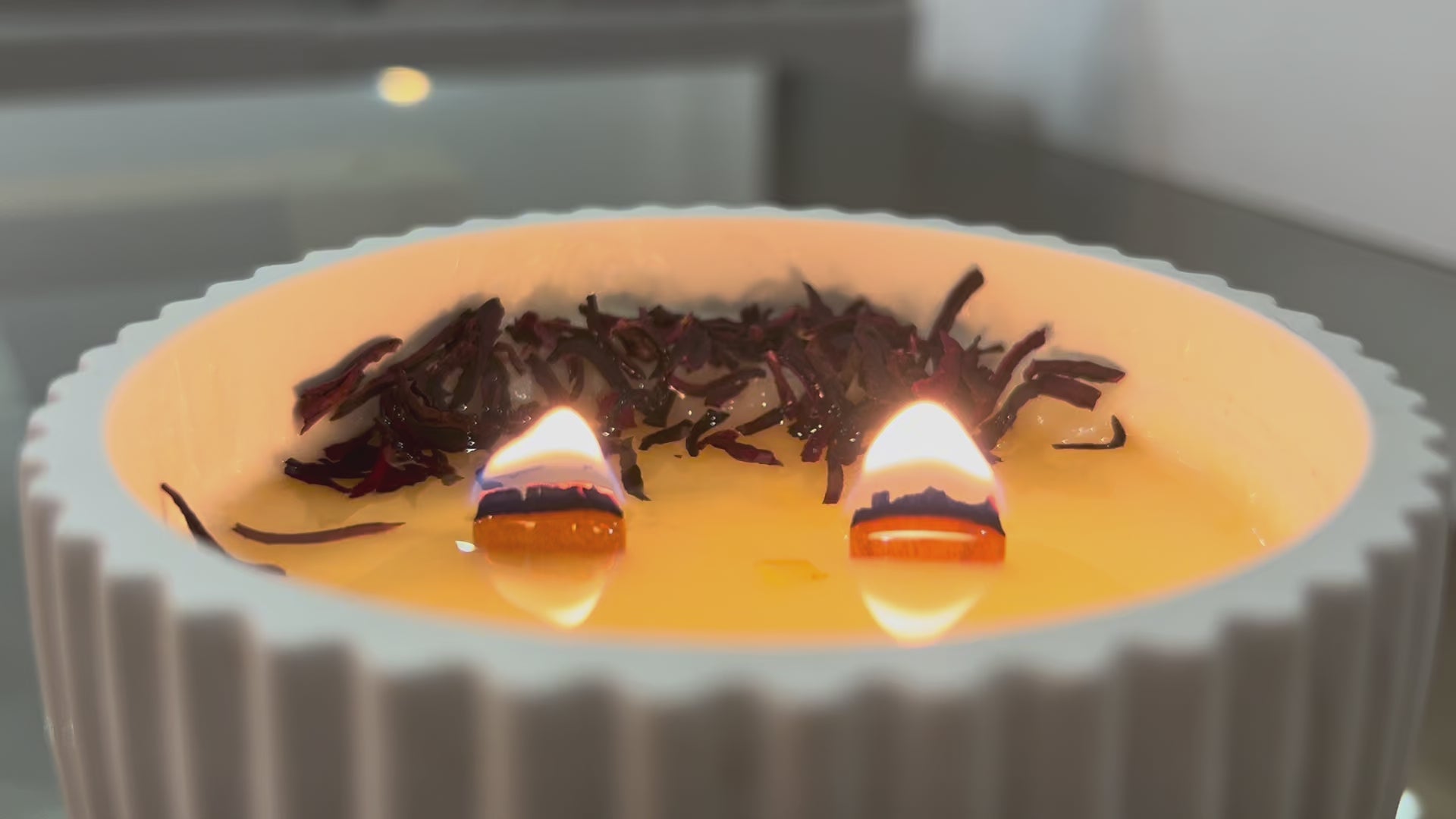 video de vela aromatica de soja de hibisco,loto y sándalo encendida con doble mecha de madera crepitante y cera fundida co adorno de flor de hibisco