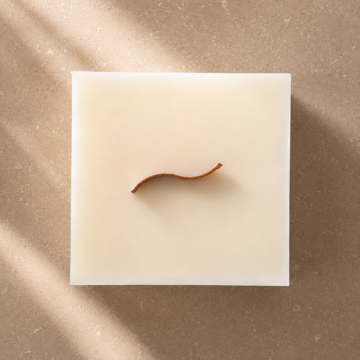 Vista superior de una vela decorativa de cera de soja en forma de cubo con mecha ondulada de madera, perteneciente a la colección Altea de Shiro Candles Studio, sobre un fondo cálido y minimalista