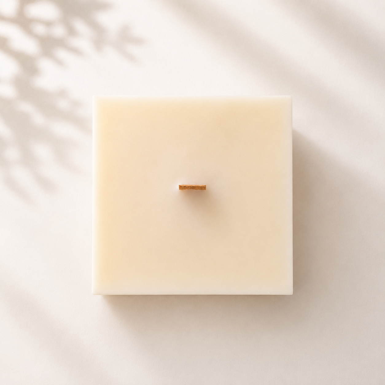 Vista superior de una vela decorativa de cera de soja en forma de cubo con mecha recta de madera, perteneciente a la Colección Altea de Shiro Candles Studio.