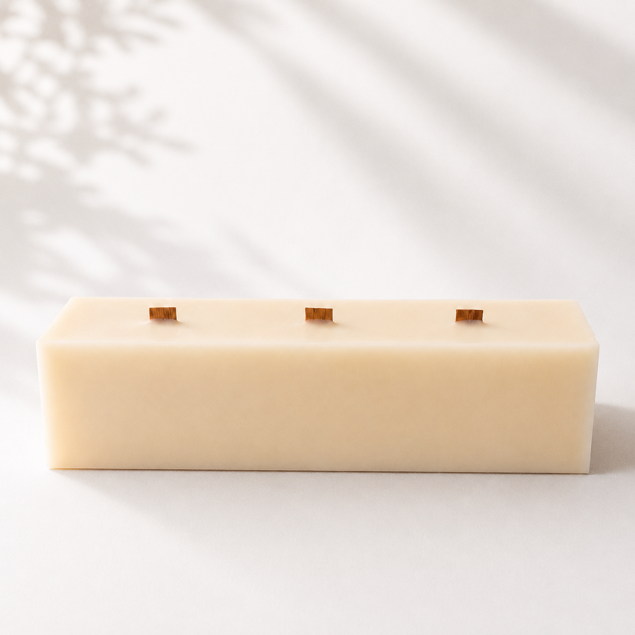 Vista frontal de una vela decorativa de cera de soja con triple mecha de madera, perteneciente a la Colección Altea de Shiro Candles Studio, de diseño minimalista